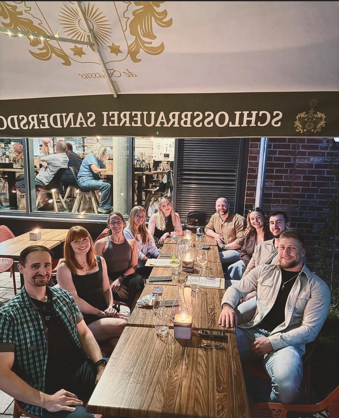 The Coaching Central team in the evening at a long table under a parasol, team meetup 2025