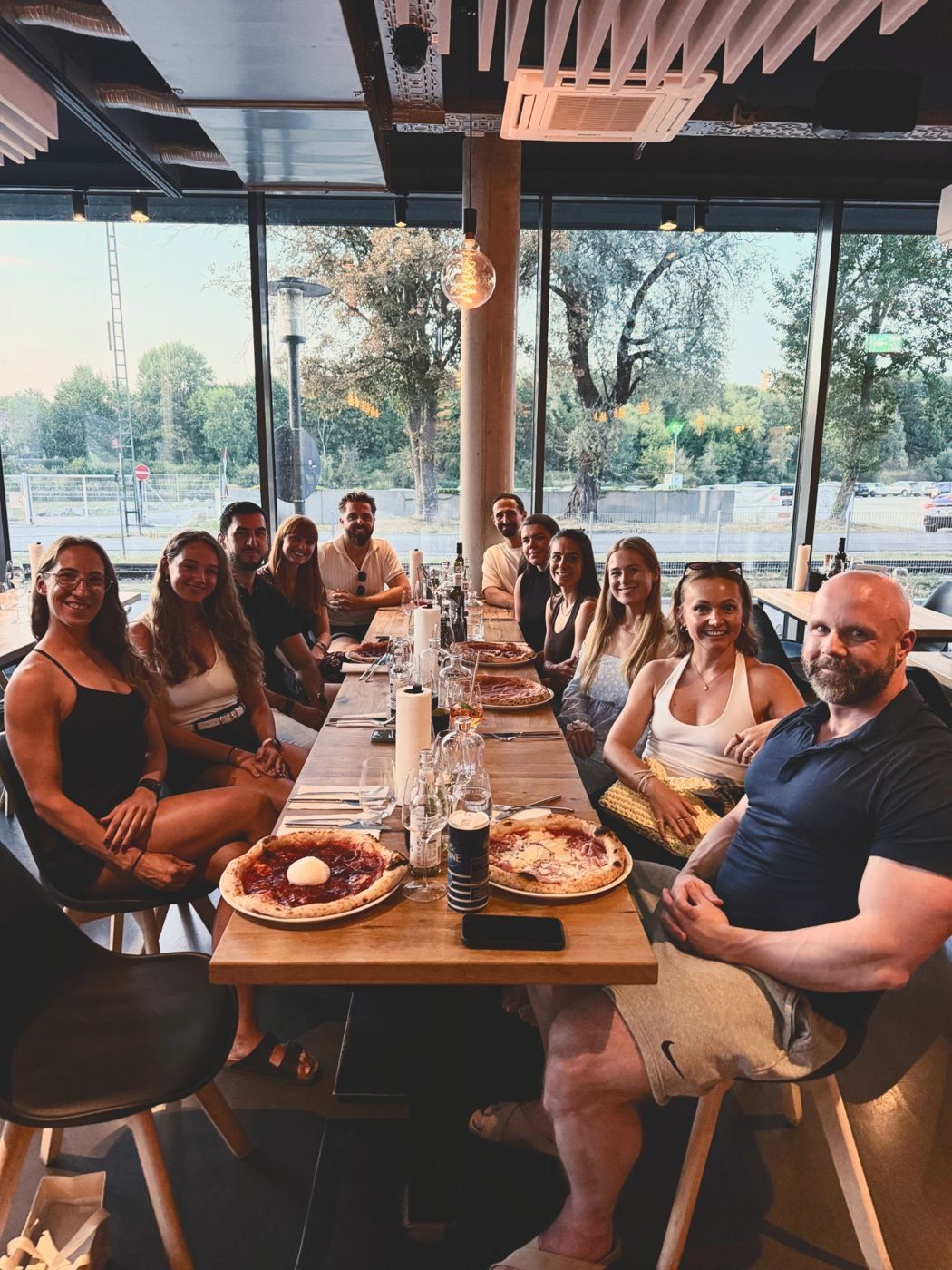 The Coaching Central team eating pizza together at a long table, team meetup 2026